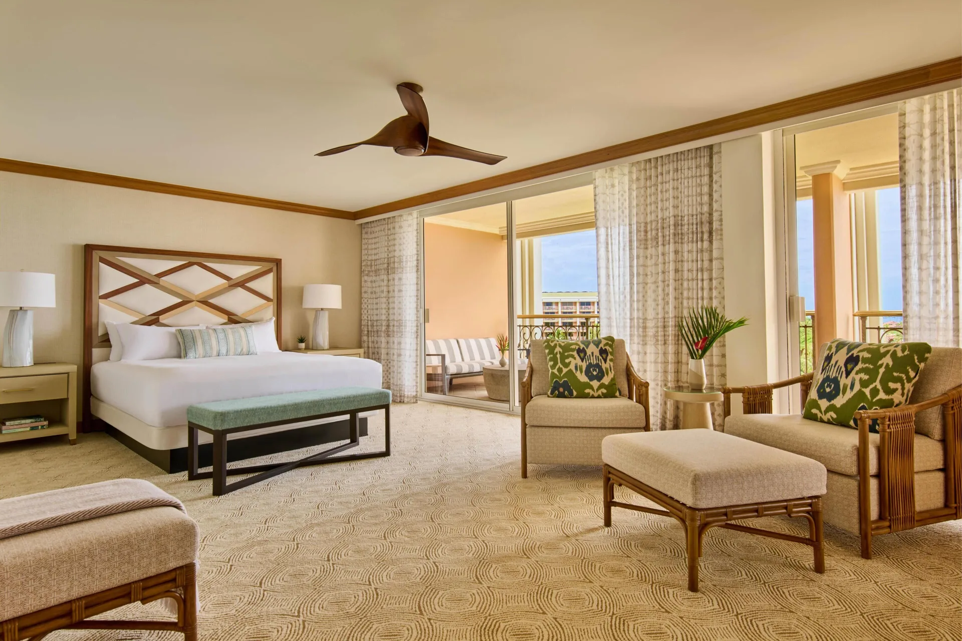 Napua Puakea Suite bedroom with king bed and balcony seating at Grand Wailea Maui.