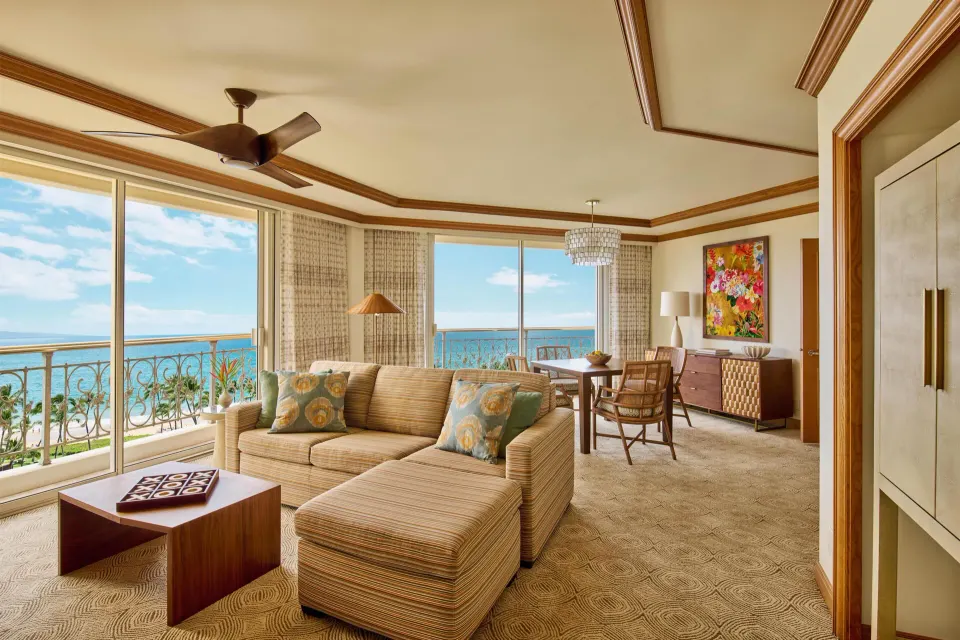 Napua Puakea Suite sitting and dining area with ocean-facing windows at Grand Wailea Maui.