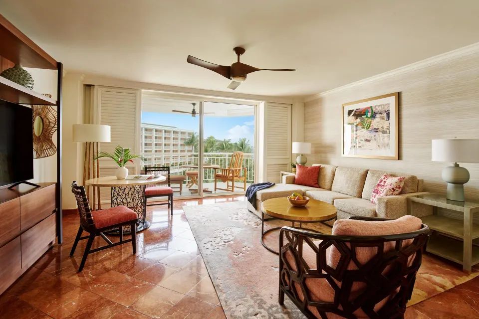 Club Suite living room with sofa, dining table, TV, and balcony at Grand Wailea Maui.