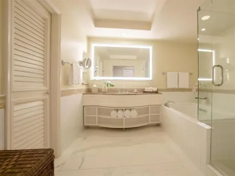 Deluxe Room Ocean View bathroom with vanity, tub, and glass shower at Grand Wailea Maui.