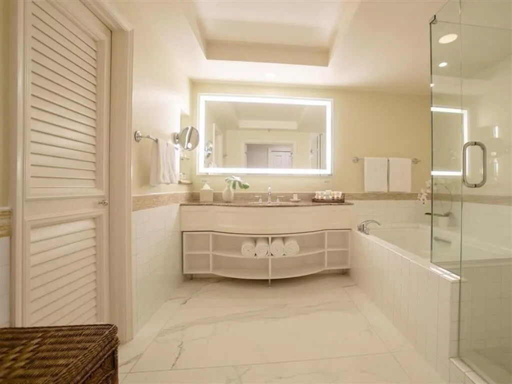 Deluxe Room Ocean View bathroom with vanity, tub, and glass shower at Grand Wailea Maui.