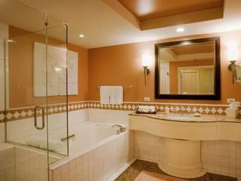 Deluxe Room Ocean View bathroom with glass shower, tub and vanity at Grand Wailea Maui.