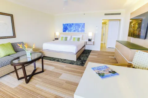 Deluxe Room Ocean View with king bed, sofa, table and TV at Grand Wailea Maui.