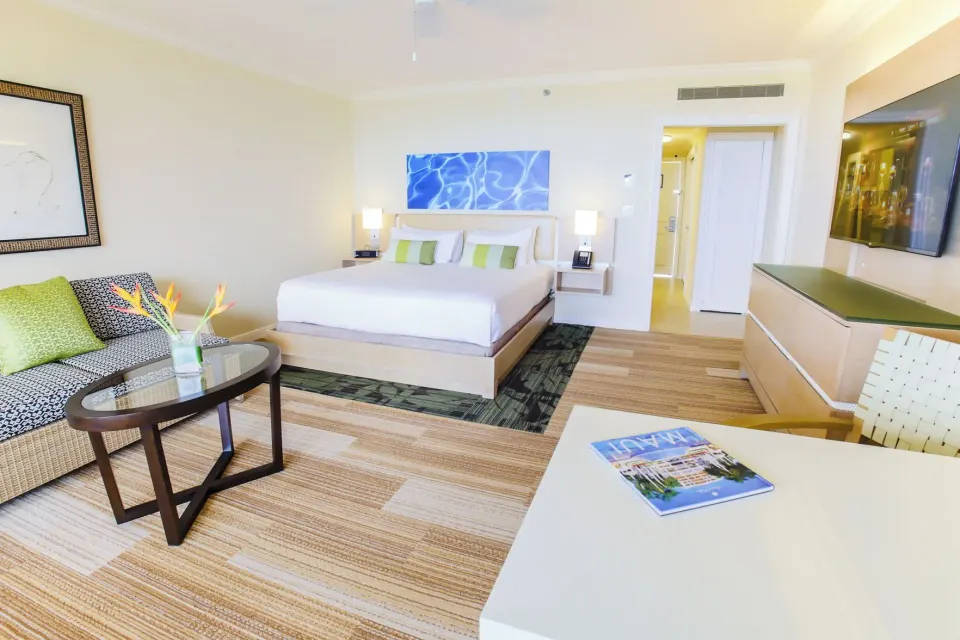 Deluxe Room Ocean View with king bed, sofa, table and TV at Grand Wailea Maui.