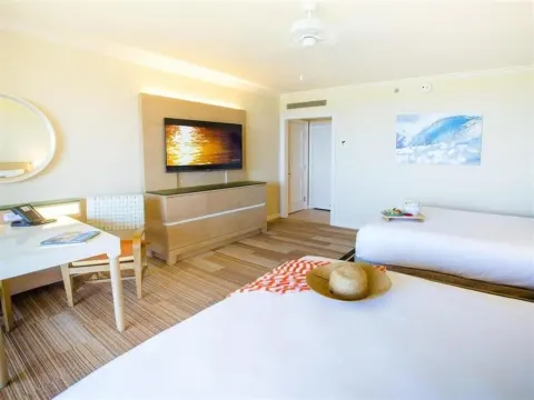 Deluxe Room Ocean View with two beds, TV, and desk at Grand Wailea Maui.