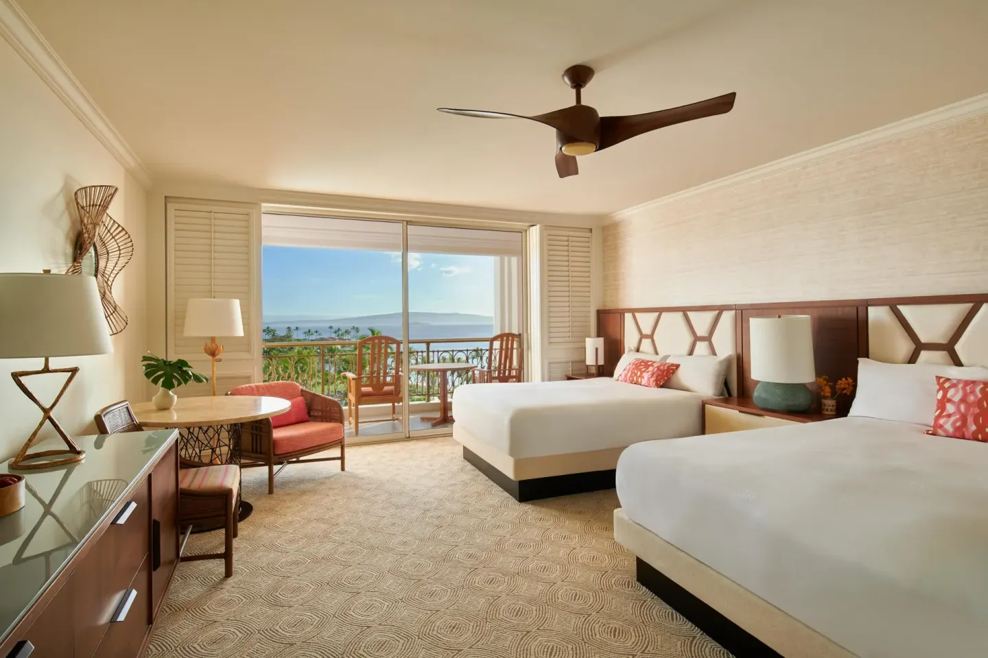 Two queen beds in a Deluxe Ocean View room at Grand Wailea Maui with balcony and ocean beyond.