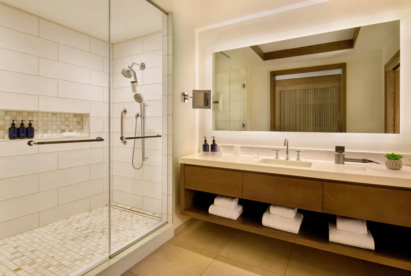 Guest bathroom with walk-in shower and long vanity at Grand Wailea Maui.