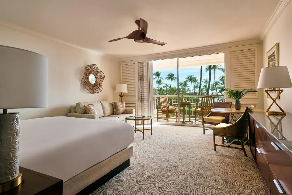 Ocean-view sofa bed room with bed, seating area, desk, and lanai at Grand Wailea Maui.
