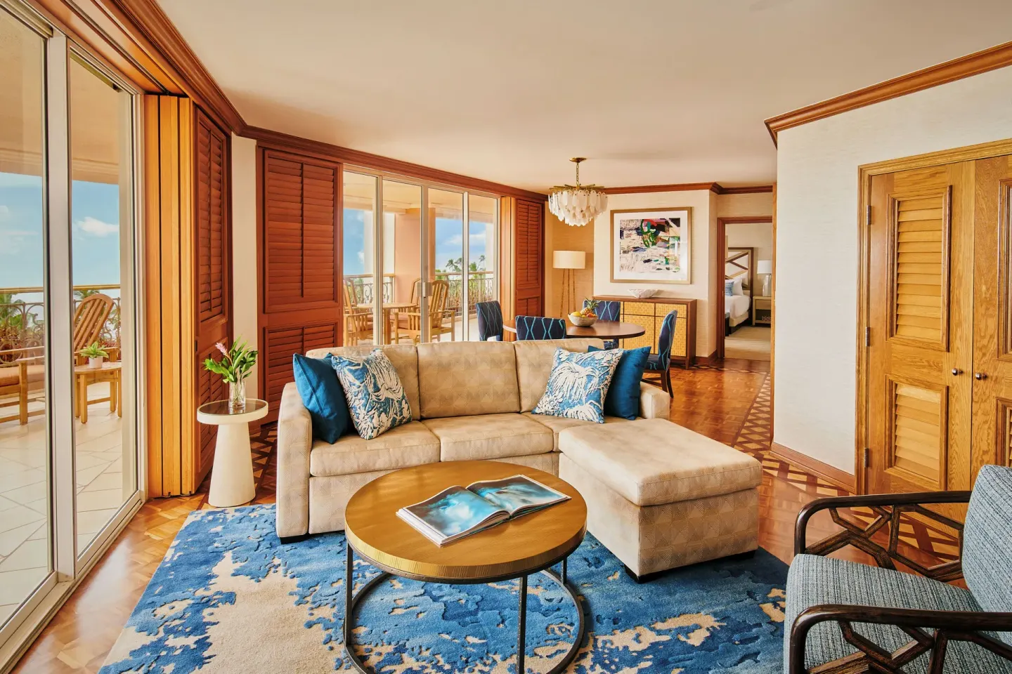 Royal Suite living room with sofa, dining area, lanai, and ocean view at Grand Wailea Maui.