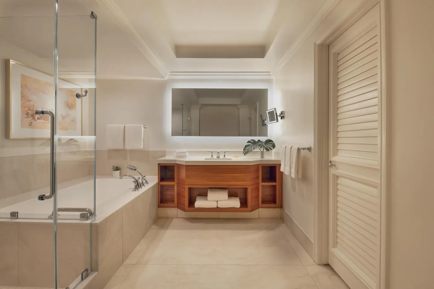 Bathroom in a one-bedroom garden view suite at Grand Wailea Maui with tub, glass shower, and vanity.