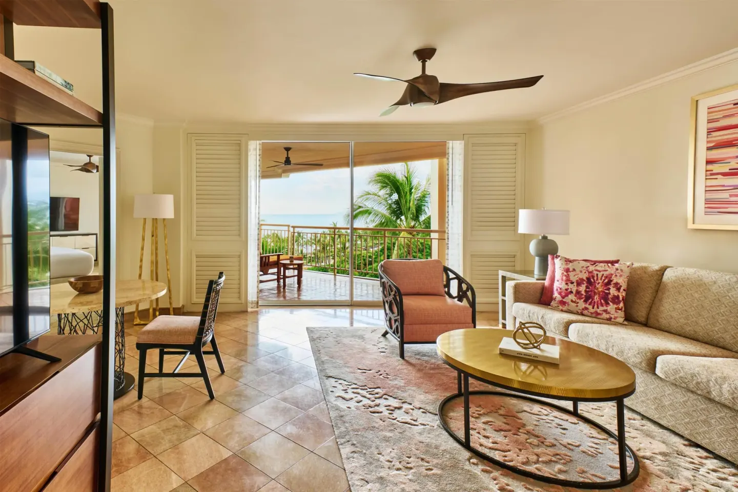 Living room in a one-bedroom garden view suite at Grand Wailea Maui with sofa, desk, and balcony.