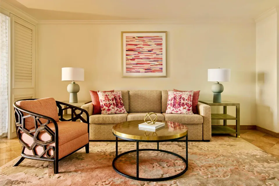 Suite living room seating at Grand Wailea Maui with sofa, armchair, lamps, and coffee table.
