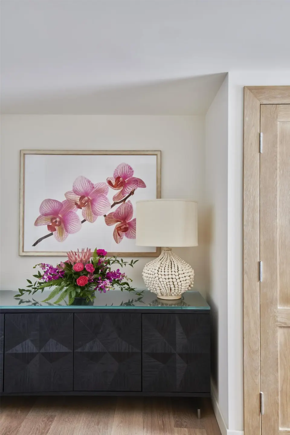 Suite entry detail with orchid artwork, flowers, and lamp at Grand Wailea Maui.