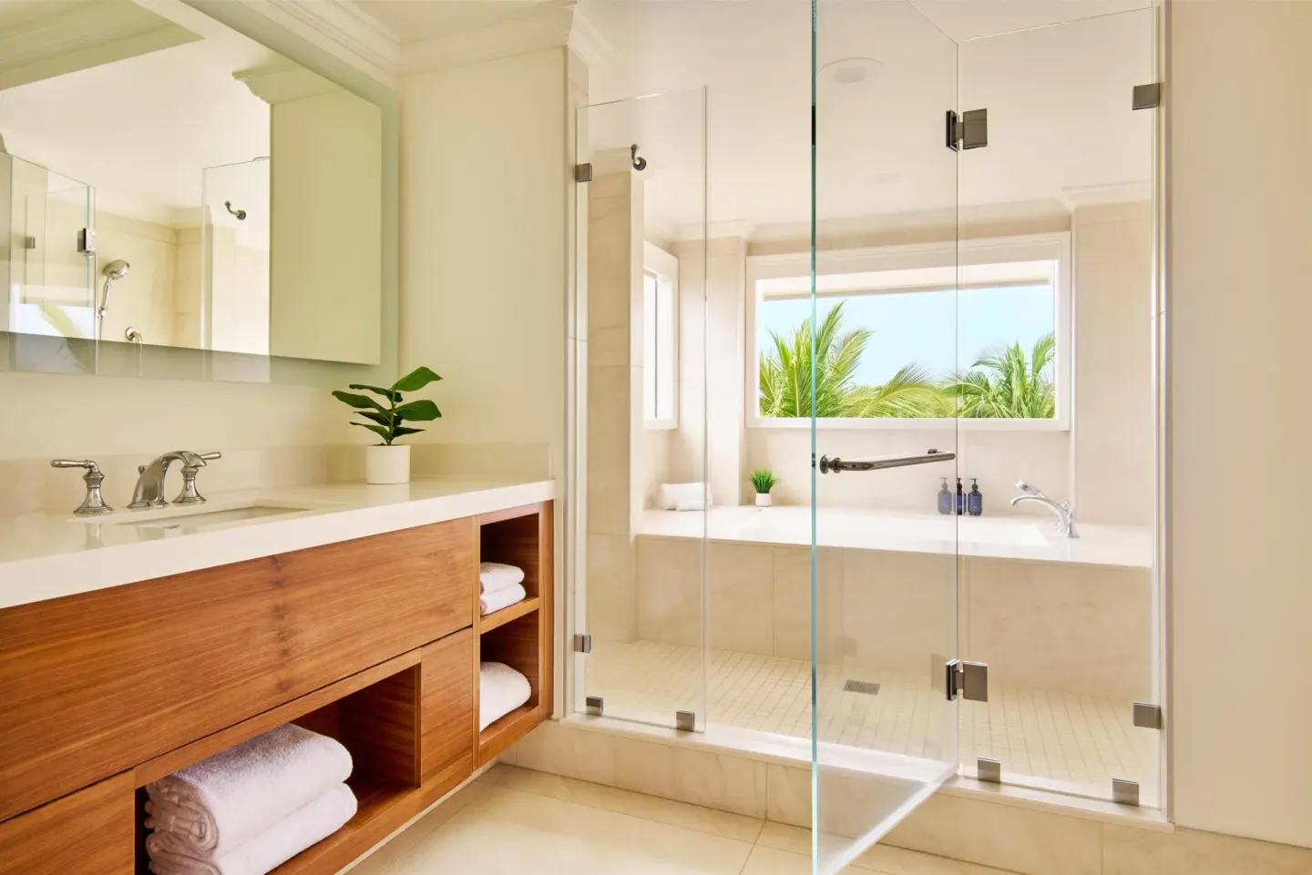 Ocean view suite bathroom with vanity, glass shower, and tub at Grand Wailea Maui.