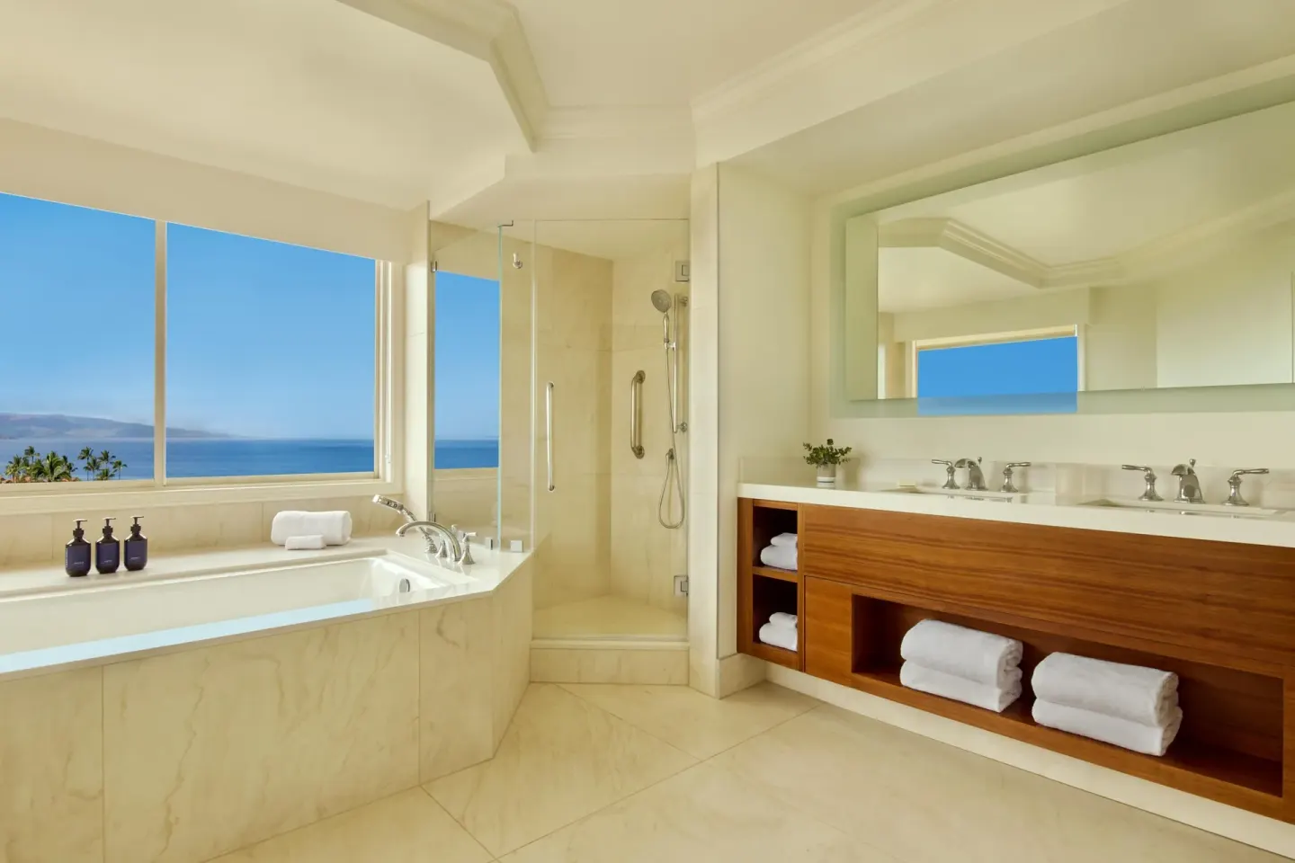Ocean-view marble bathroom with soaking tub and shower at Grand Wailea Maui.