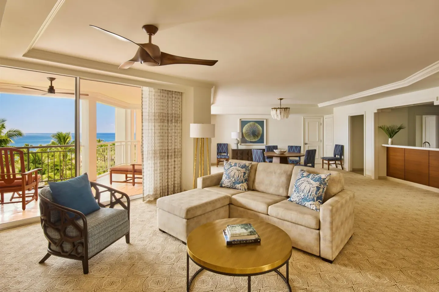 Ocean-view one-bedroom suite living room with sofa, dining area and lanai at Grand Wailea Maui.