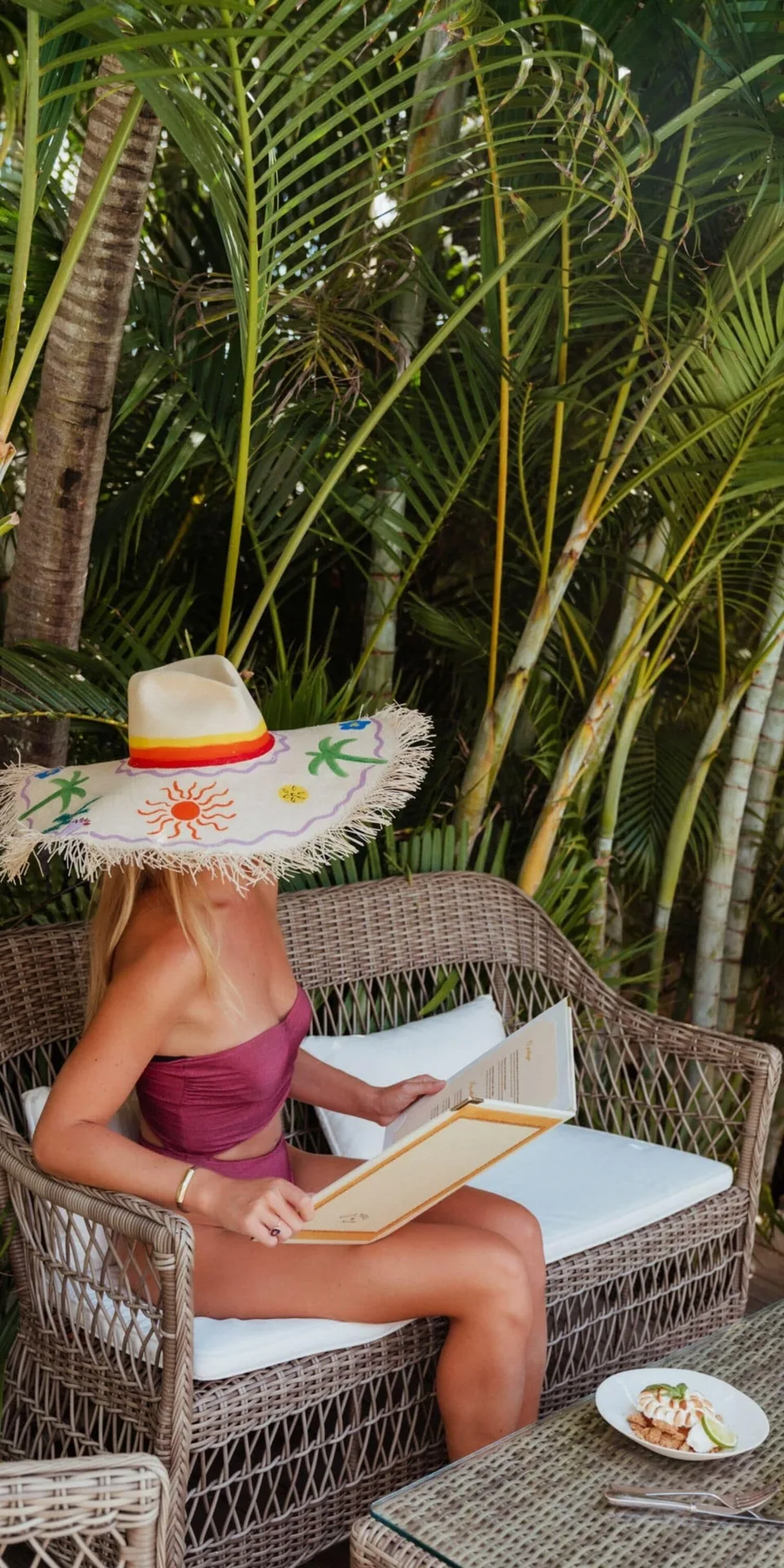 Guest reading on a wicker garden sofa at GYP SEA Saint Barth.