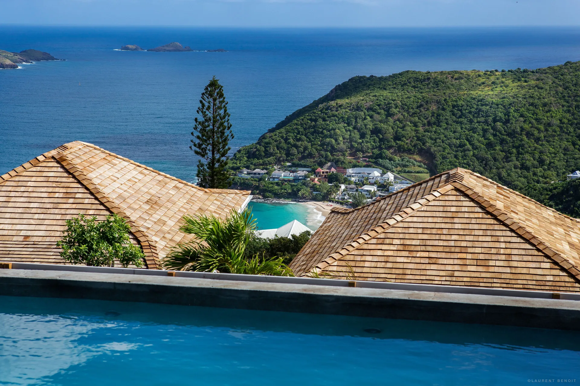 Pool edge overlooking rooftops, hills, and the sea at GYP SEA Saint Barth.