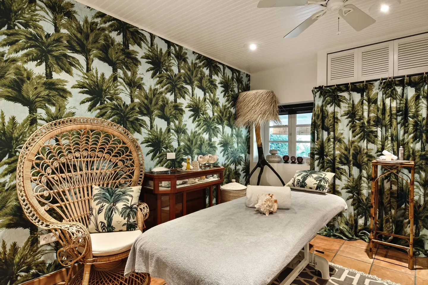 Spa treatment room with palm-print walls and massage table at GYP SEA Saint Barth.