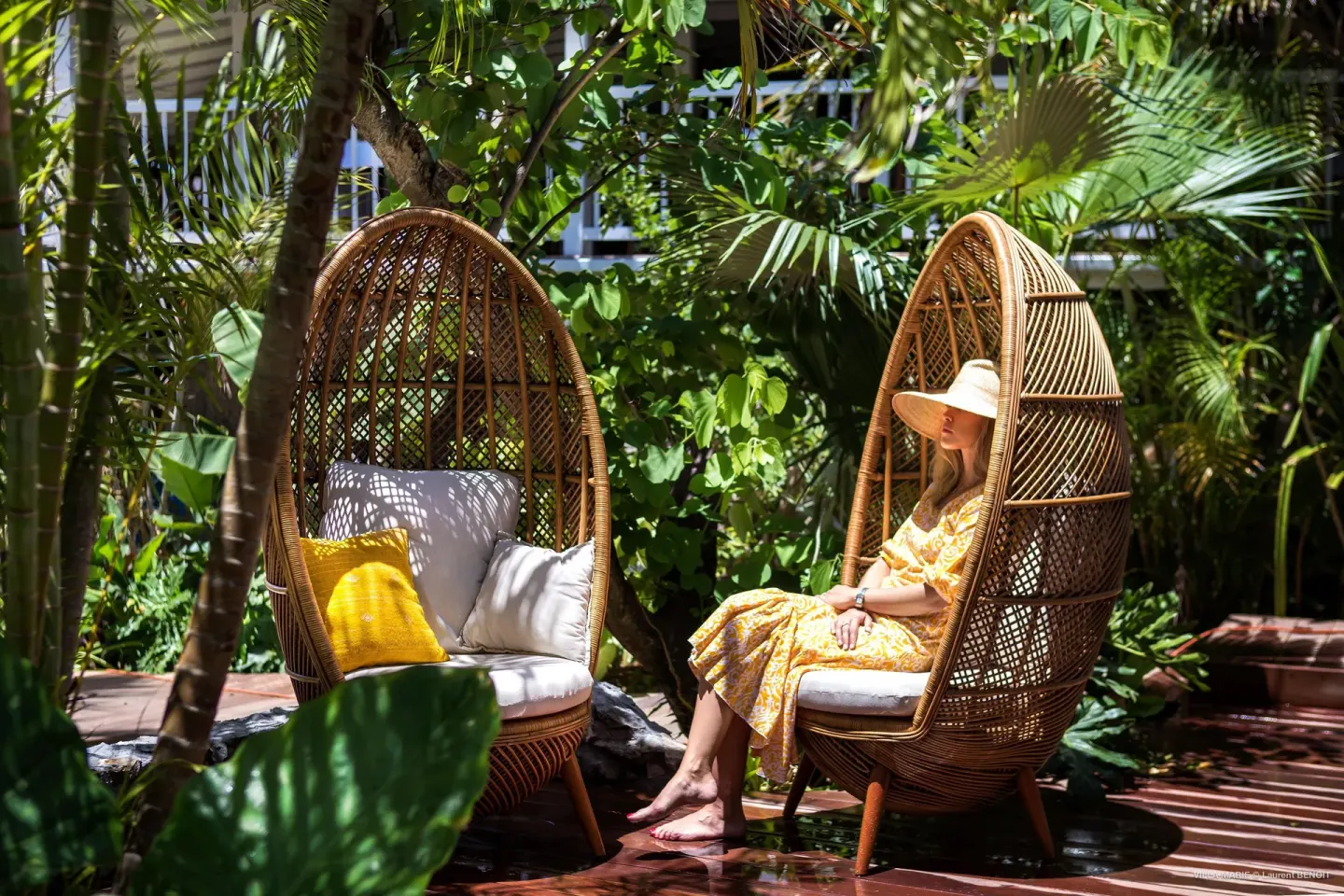 Wicker garden chairs under tropical foliage at GYP SEA Saint Barth.