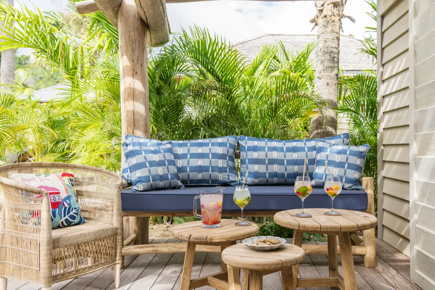 Covered terrace seating with blue cushions and drinks at GYP SEA Saint Barth.