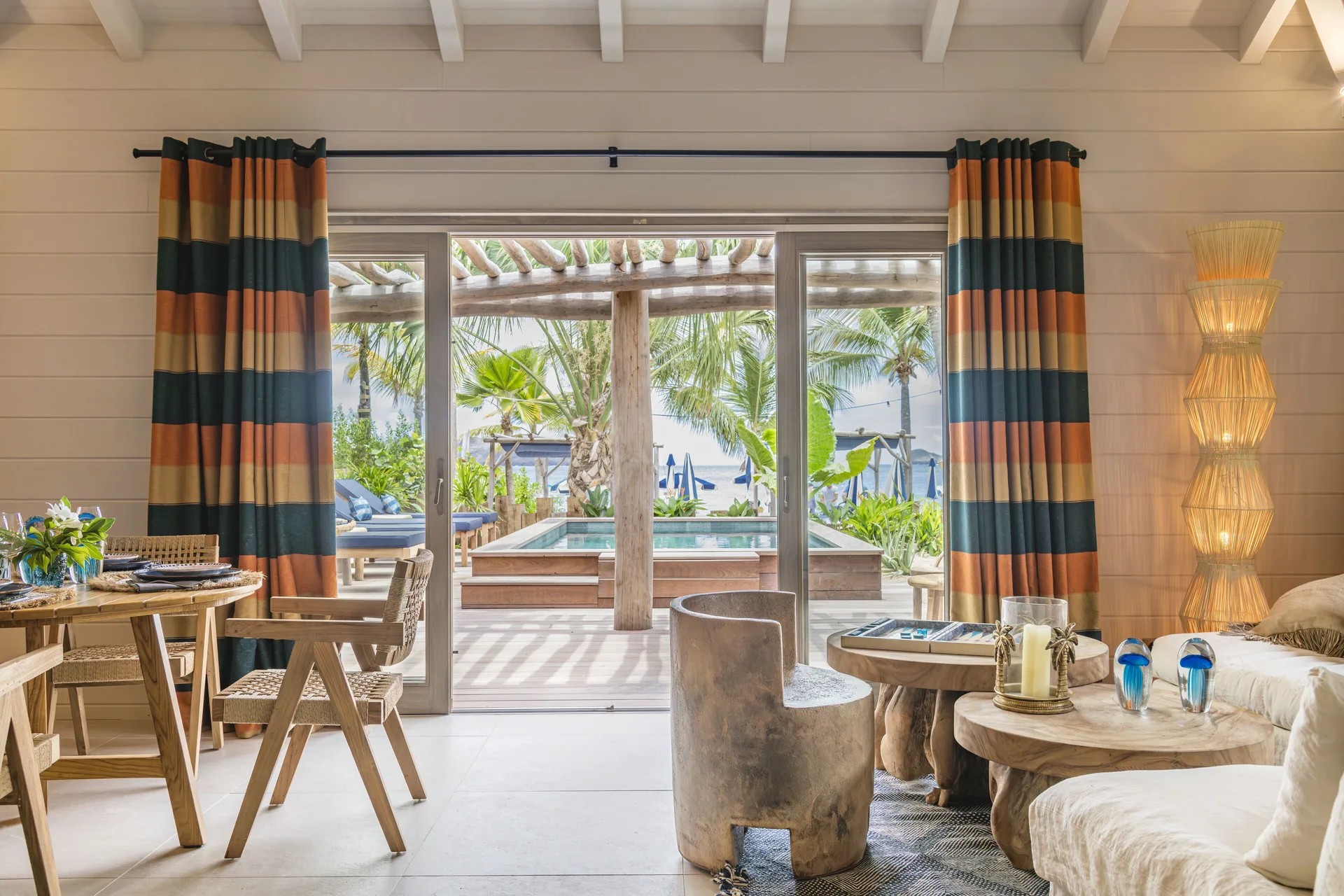 Living area opening to the pool terrace in Bohemian Blue Beach House at GYP SEA Saint Barth.