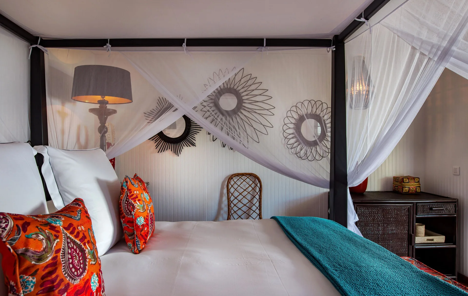 Caribbean Bungalow bed with canopy netting and colorful pillows at GYP SEA Saint Barth.