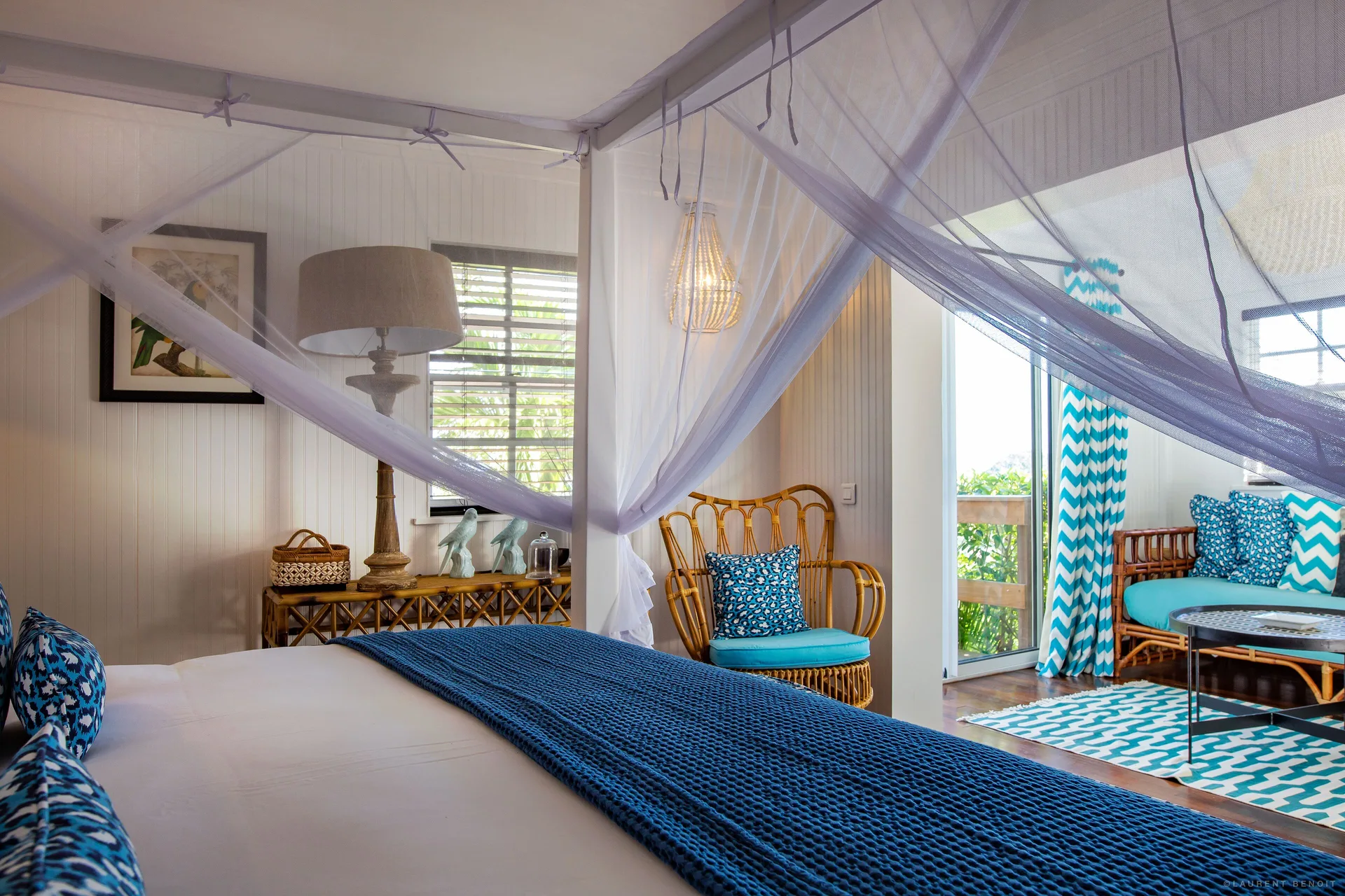 Caribbean Bungalow bed with lounge area and balcony doors at GYP SEA Saint Barth.