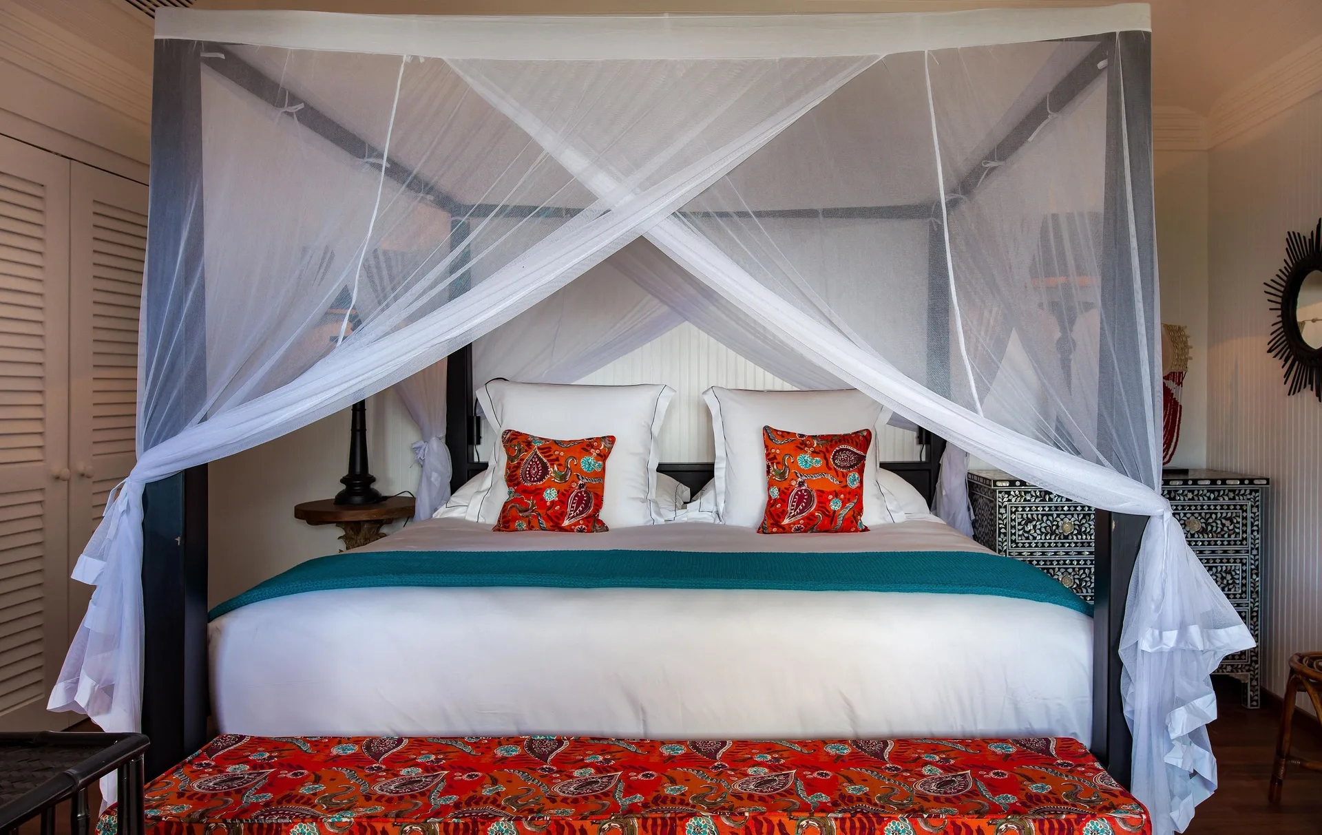 Caribbean Bungalow canopy bed with red patterned bench at GYP SEA Saint Barth.