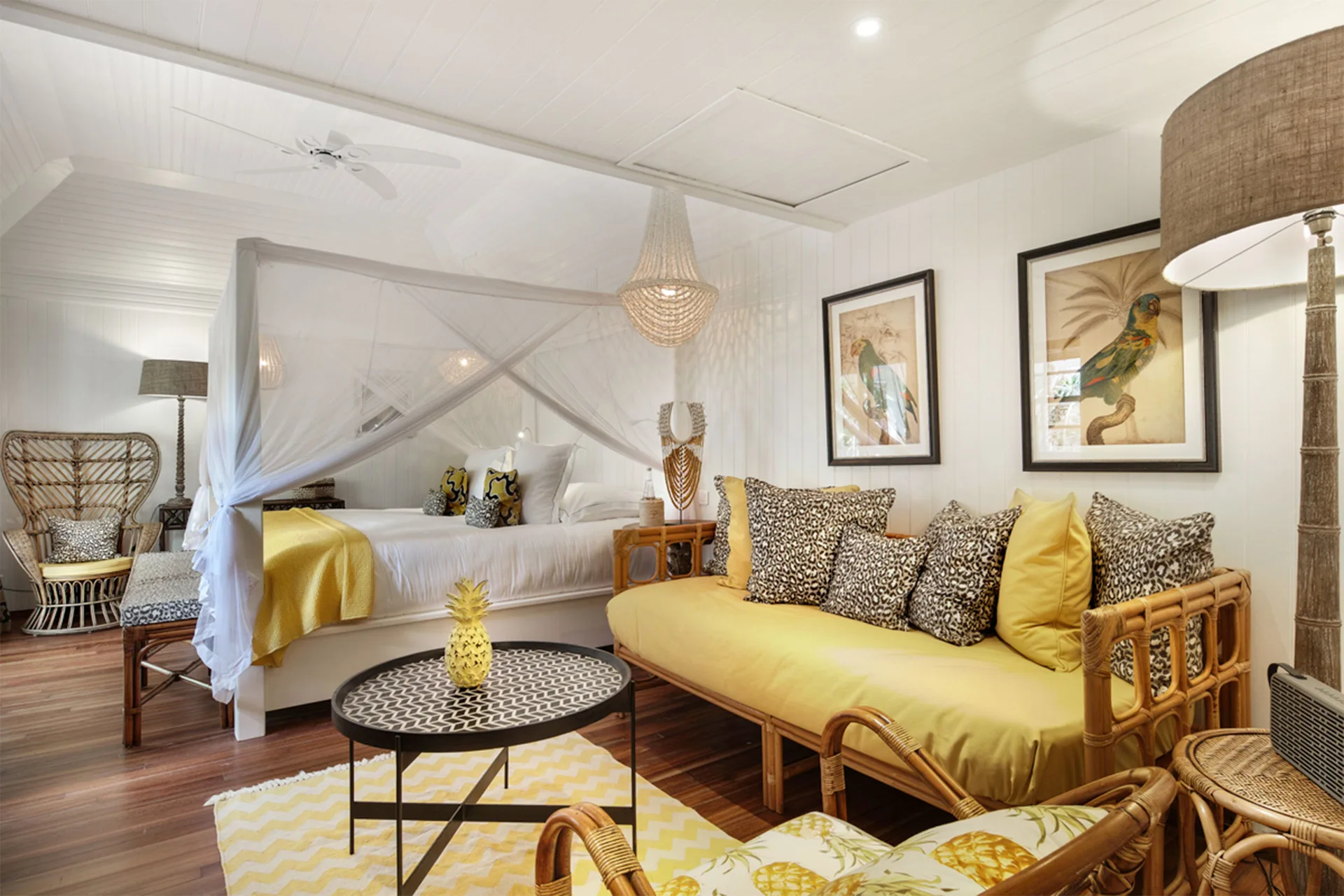 Bungalow Plantation room with canopy bed and yellow rattan sofa at GYP SEA Saint Barth.