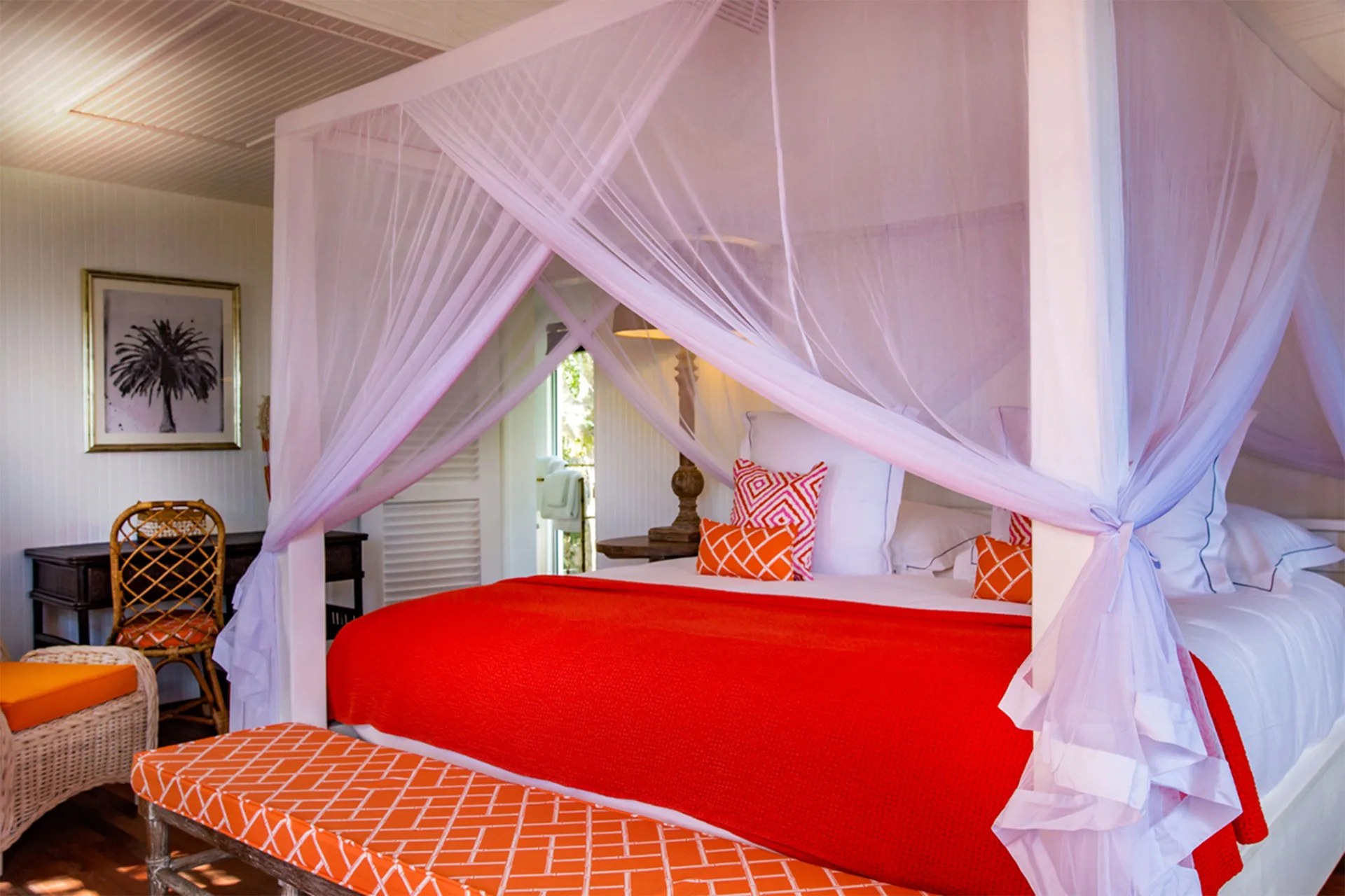 Prestige Caribbean bungalow four-poster bed with orange accents at GYP SEA Saint Barth.