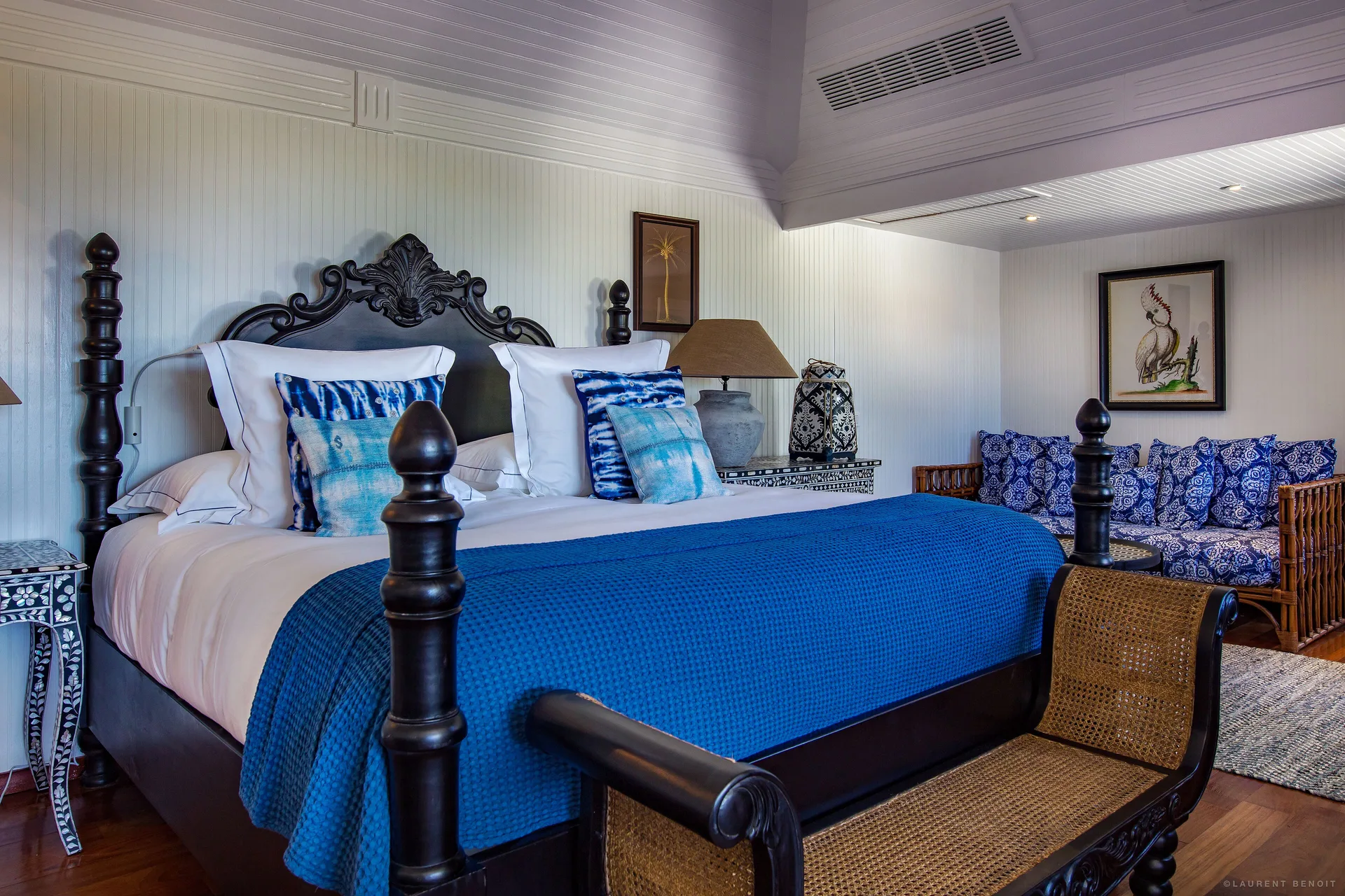Prestige Caribbean Bungalow king bed with blue textiles and sitting area at GYP SEA Saint Barth.