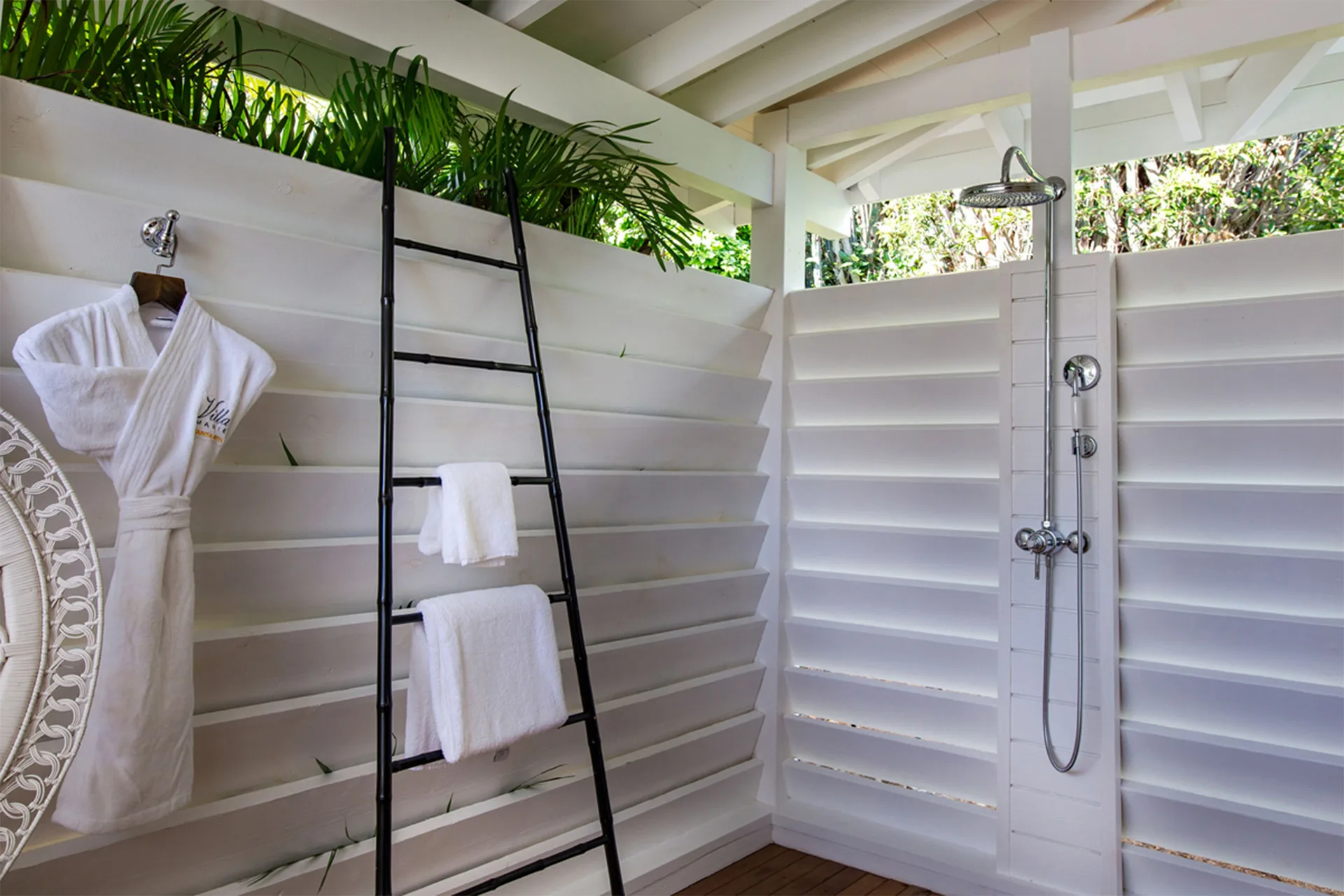 Open-air bungalow shower with robe and towels at GYP SEA Saint Barth.