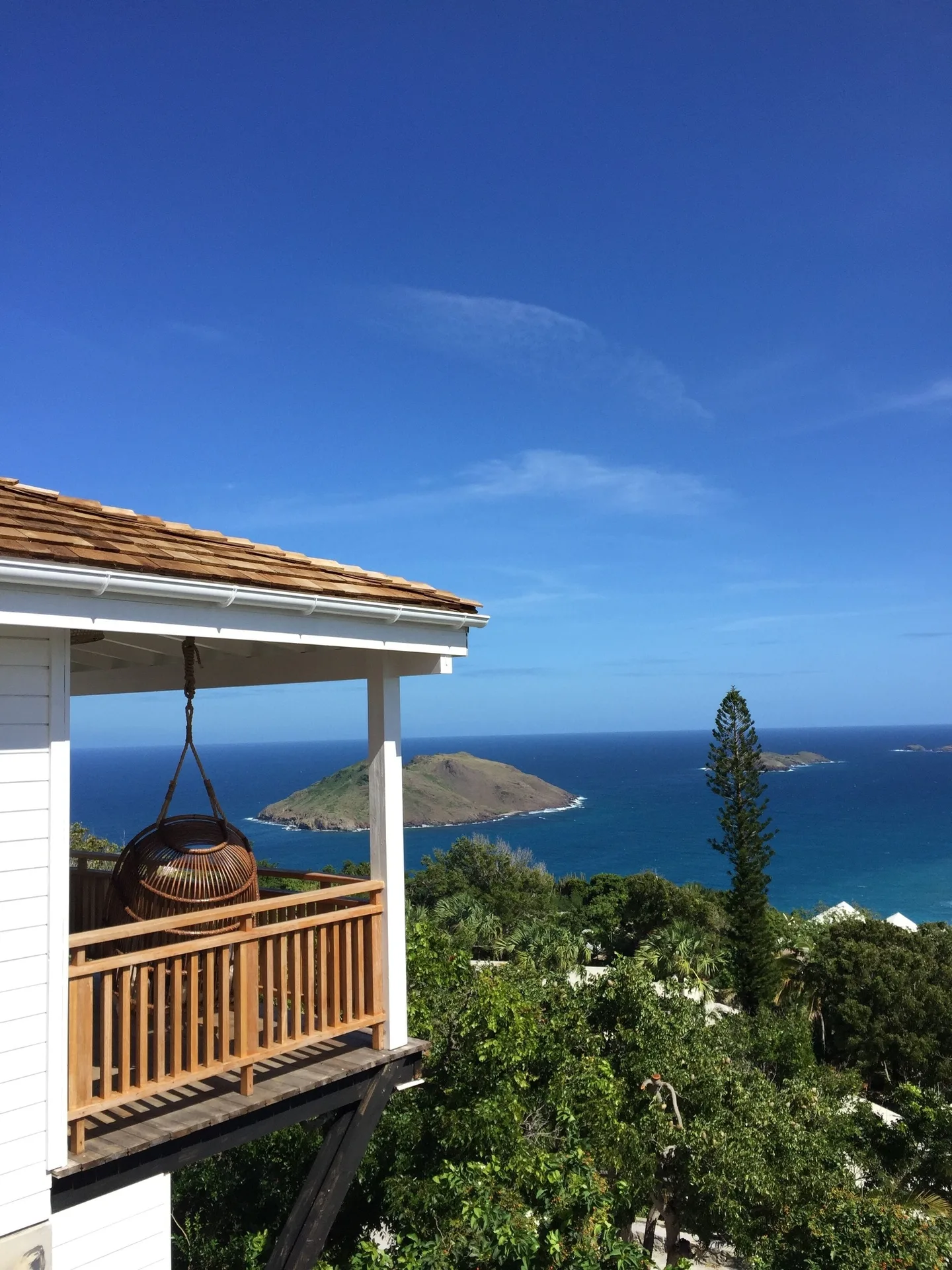 Tropical Bungalow balcony with hanging chair and island sea view at GYP SEA Saint Barth.
