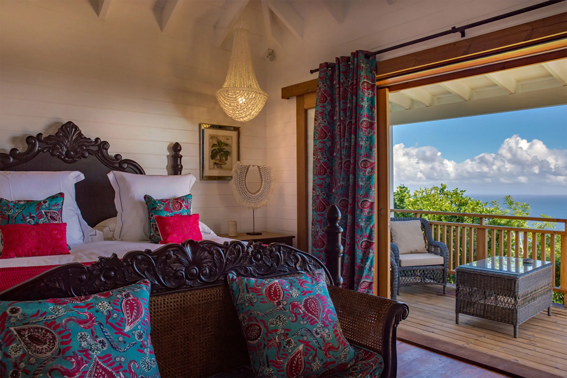 Tropical Bungalow bedroom with carved bed and balcony sea view at GYP SEA Saint Barth.