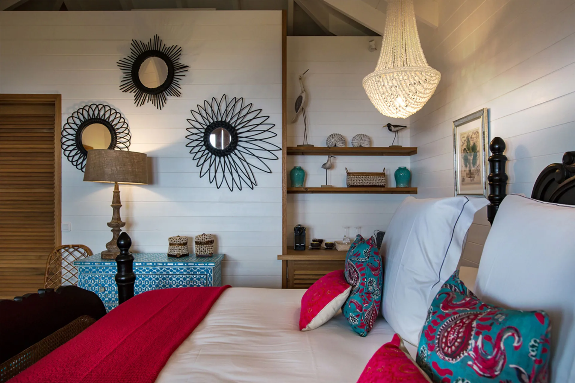 Tropical Bungalow bed with patterned pillows and wall mirrors at GYP SEA Saint Barth.