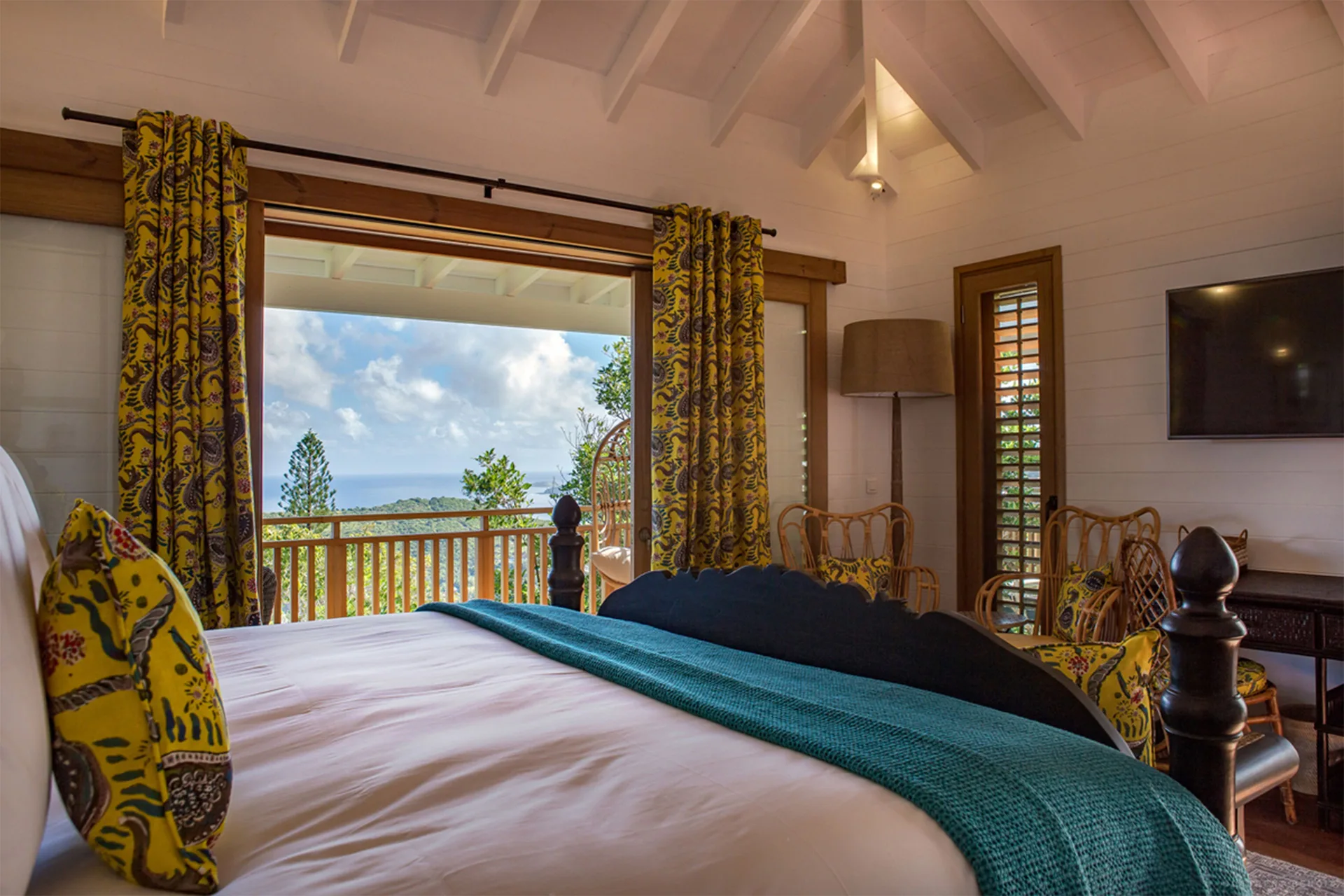 Tropical Bungalow king bed facing open balcony doors at GYP SEA Saint Barth.