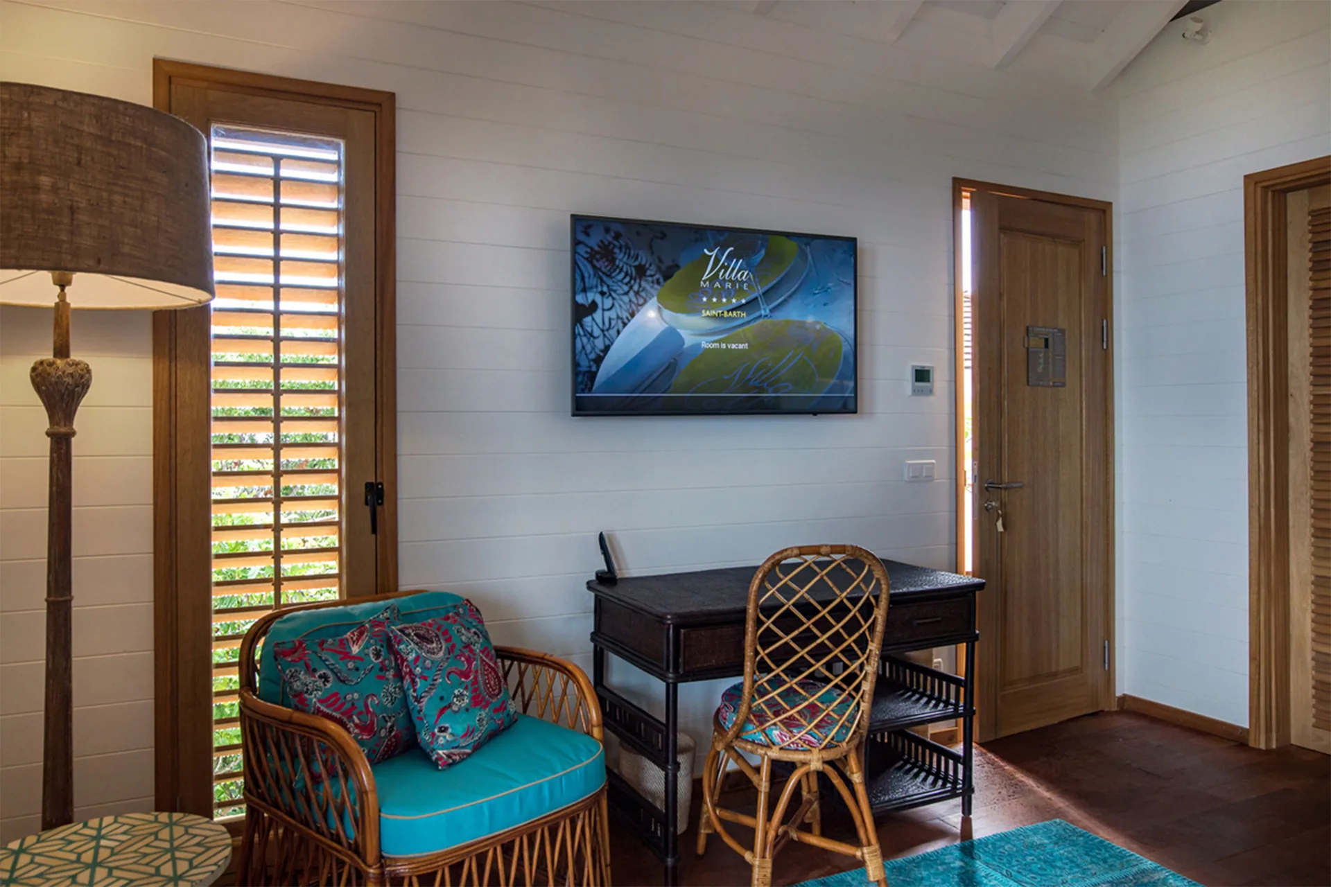 Tropical Bungalow sitting area with desk and wall-mounted TV at GYP SEA Saint Barth.