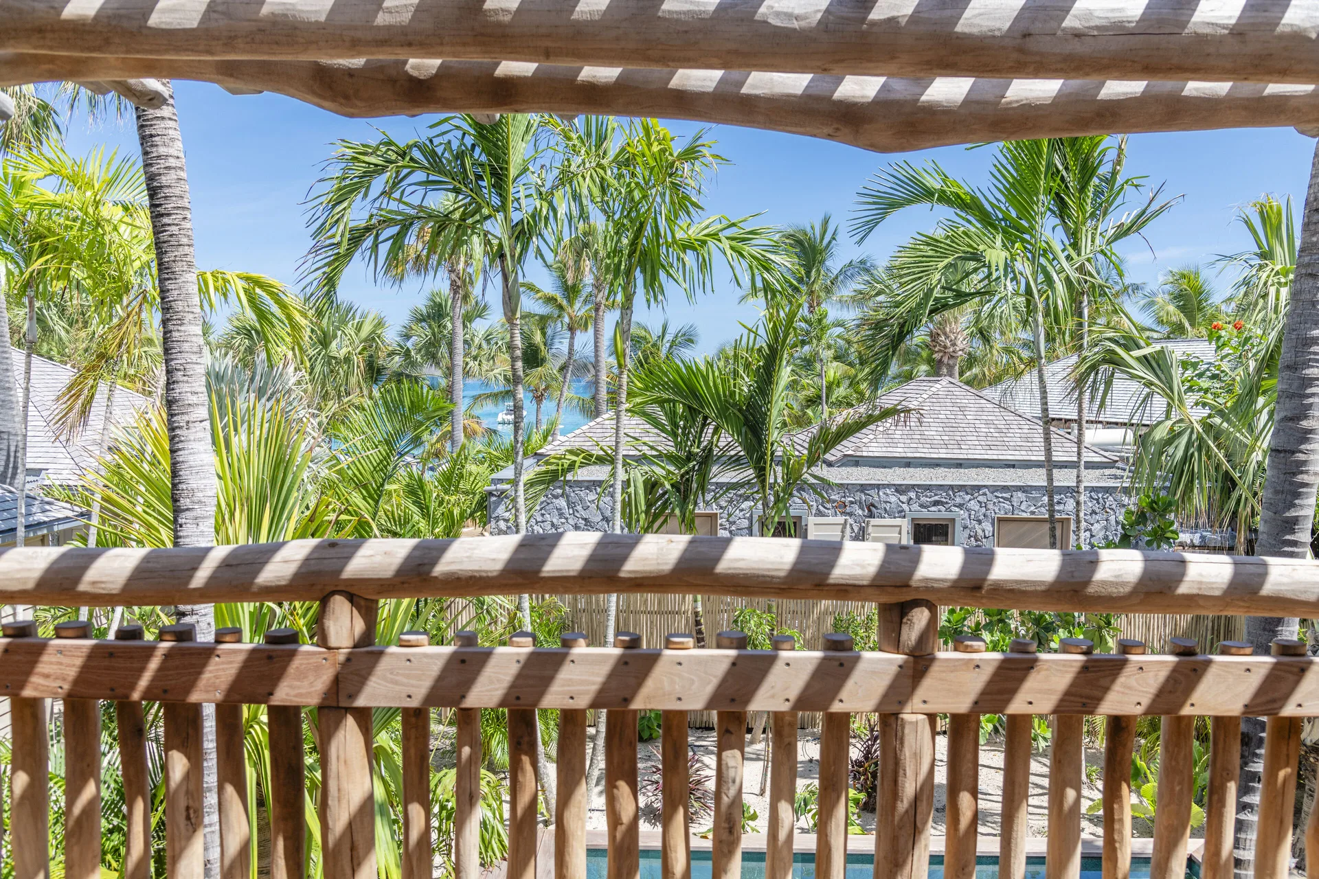 Balcony view through palms at Coco Mango Beach House at GYP SEA Saint Barth.