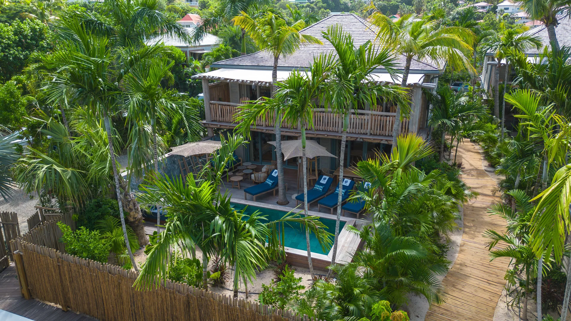 Tropical villa exterior with pool, loungers and palms at GYP SEA Saint Barth.