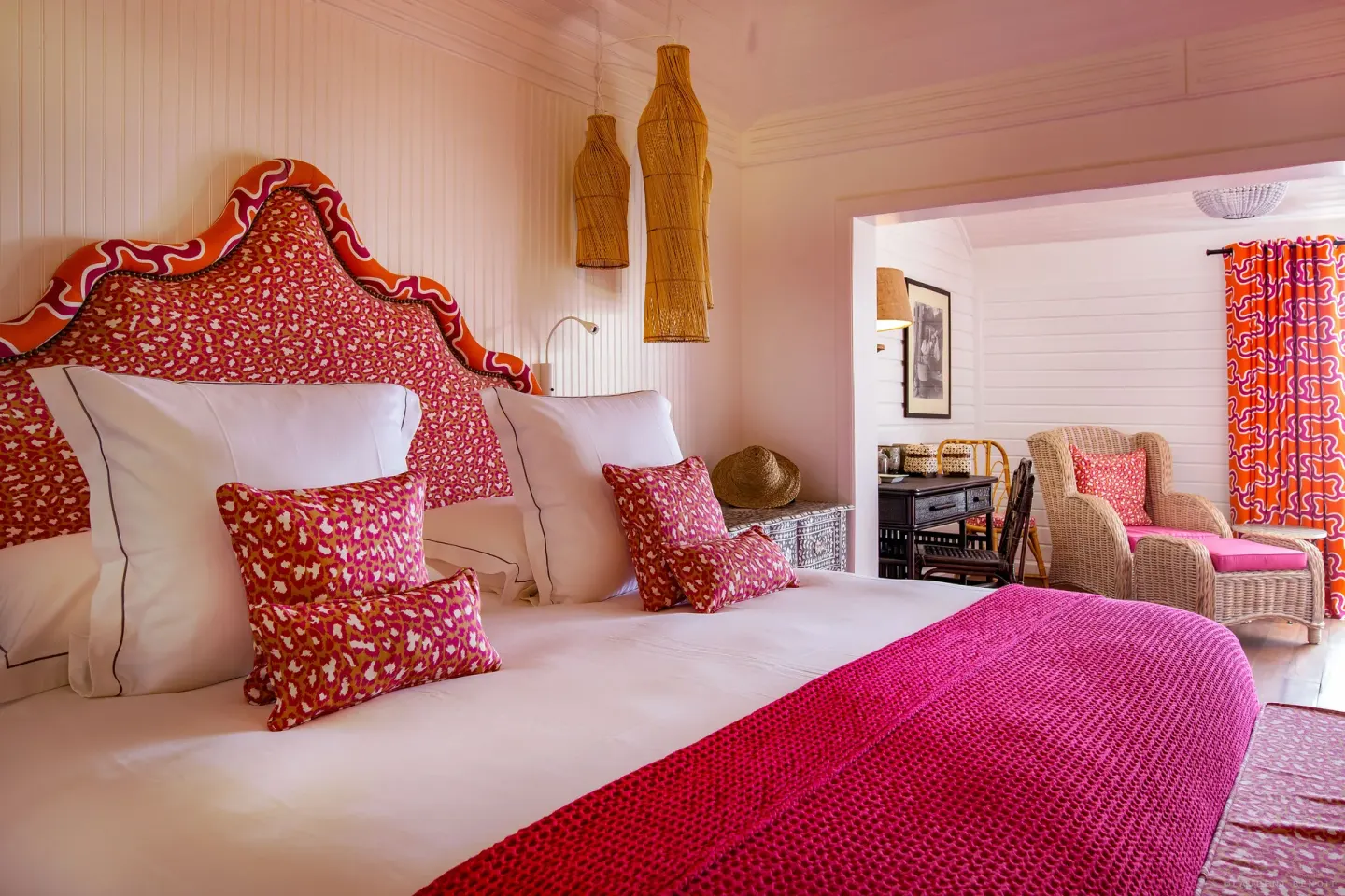 Family Suite king bed with bright pink accents at GYP SEA Saint Barth.