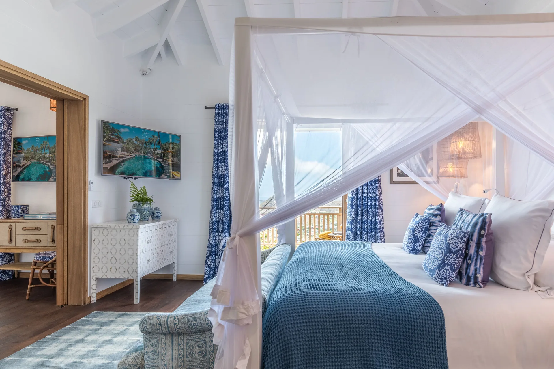Havana Suite bedroom with canopy bed and balcony at GYP SEA Saint Barth.