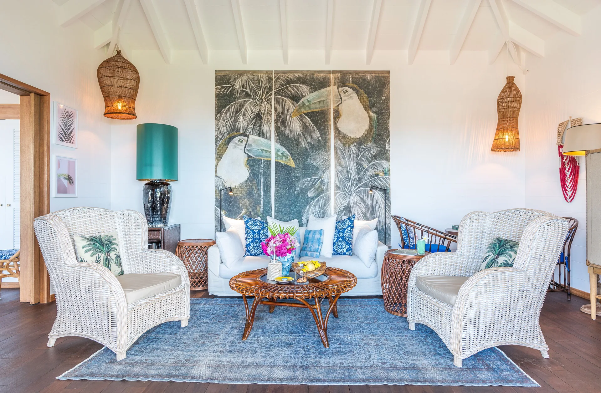 Havana Suite sitting room with white wicker chairs and tropical artwork at GYP SEA Saint Barth.