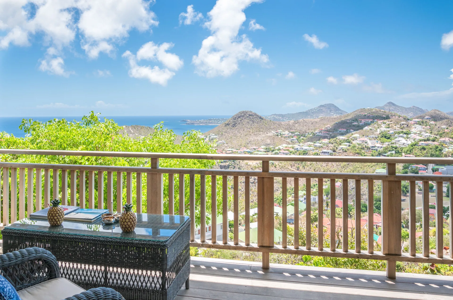 Havana Suite terrace with wicker seating and hillside ocean view at GYP SEA Saint Barth.