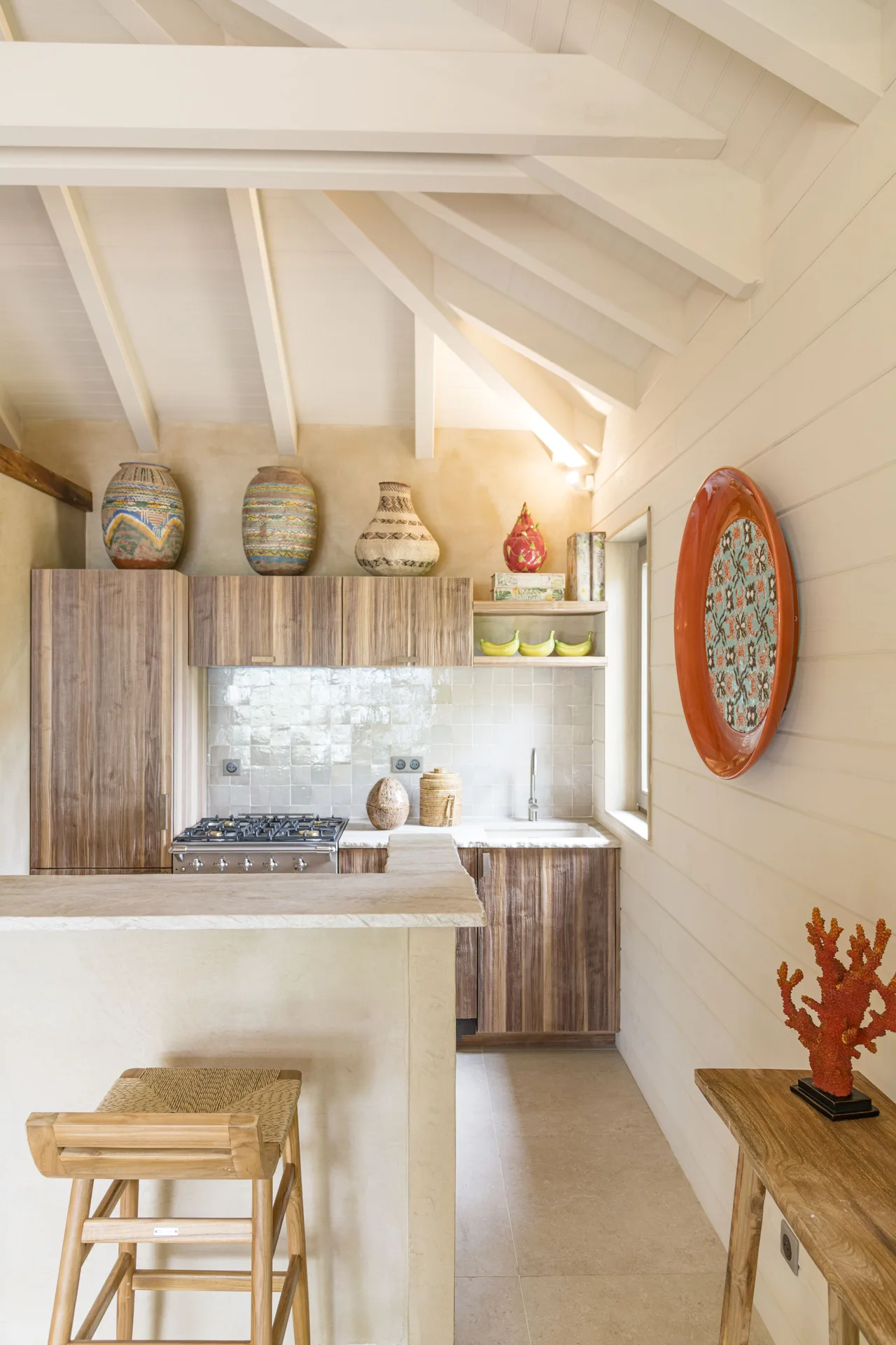 Kitchenette with wood cabinetry and island at GYP SEA Saint Barth.