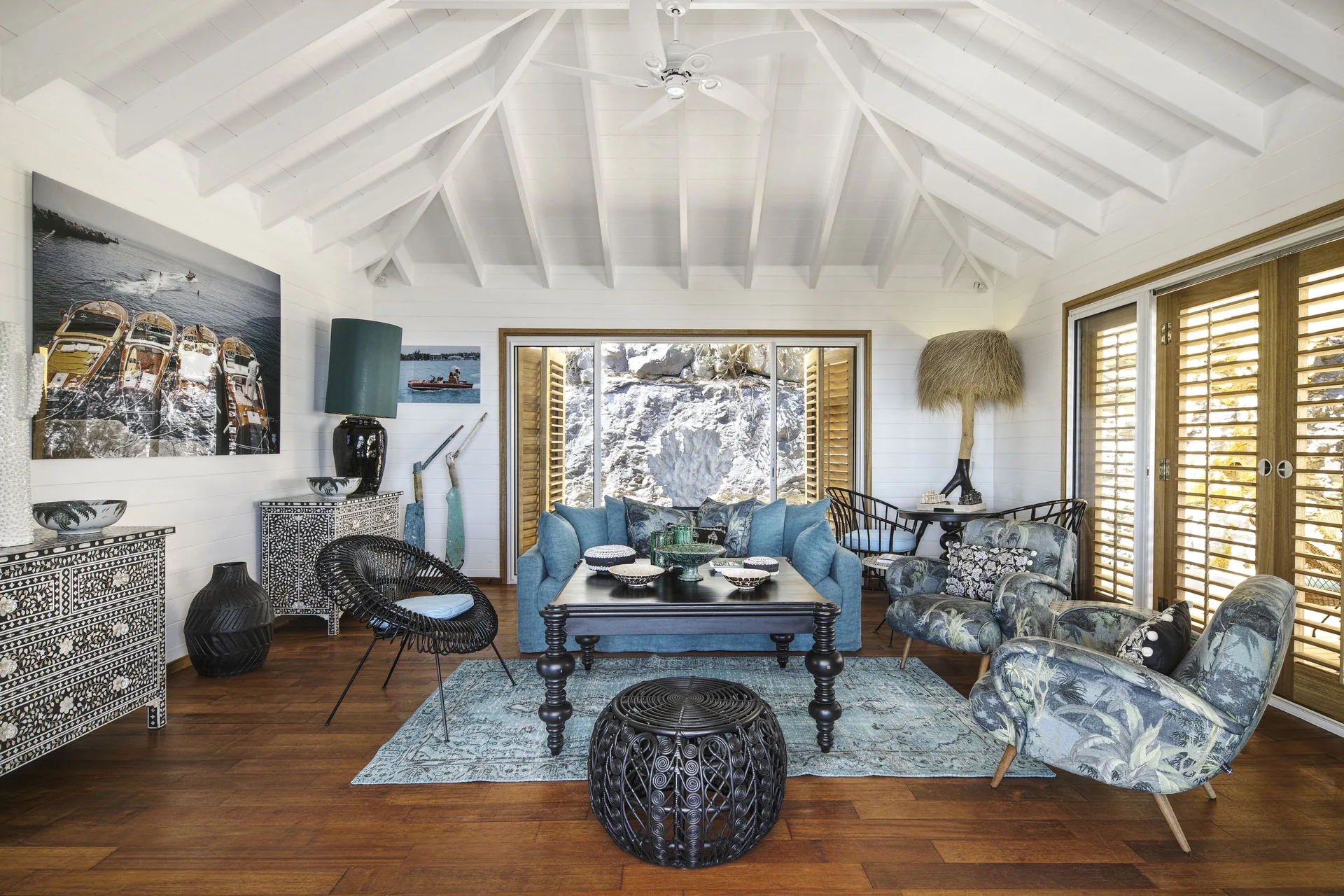 Villa living room with blue sofa and patterned chairs at GYP SEA Saint Barth.