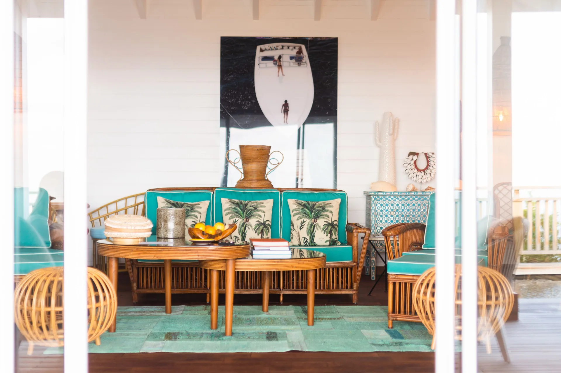 Villa sitting area with rattan sofa and turquoise cushions at GYP SEA Saint Barth.