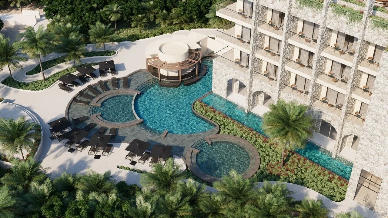 Aerial view of pool decks by a resort building at Hacienda Tres Rios Resort, Spa & Nature Park.