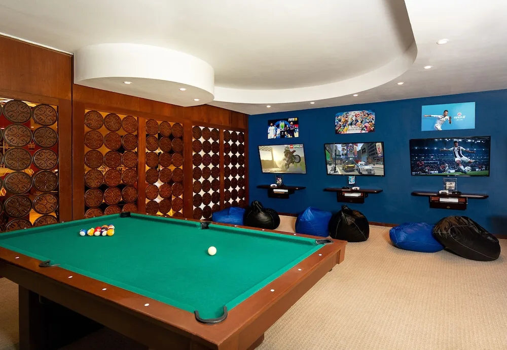 Game room with pool table and video screens at Hacienda Tres Rios Resort, Spa & Nature Park.