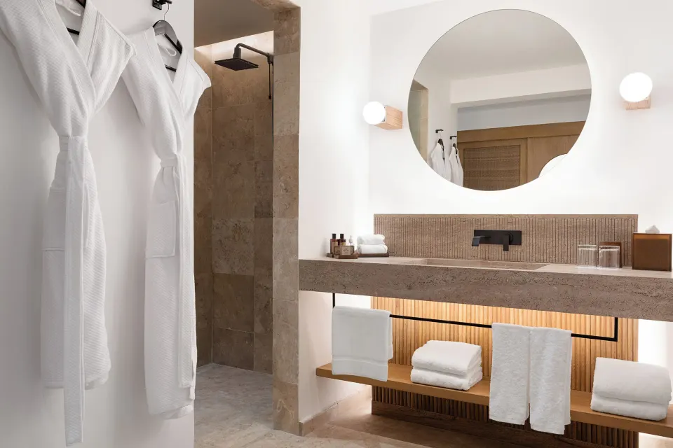 Guest bathroom with robes and vanity at Hacienda Tres Rios Resort, Spa & Nature Park.